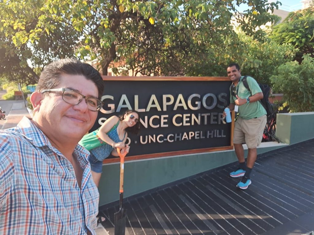 Selfie of Antonio León (foreground), Noelia Nathaly Medina (middle), and Senay Yitbarek (right) in front of the Galapagos Science Center sign.