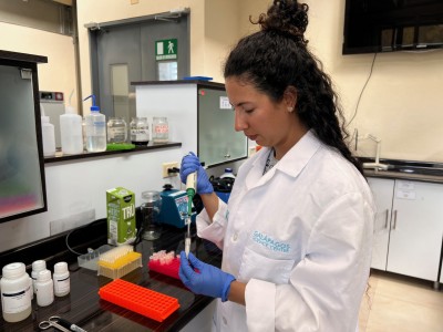 Salomé Jaramillo Gil in a GSC lab, wearing a lab coat and using a pipette.
